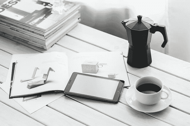 Foto Tablet, tasa de café y libros